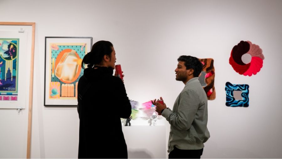 Two people talking to each other in an art gallery.