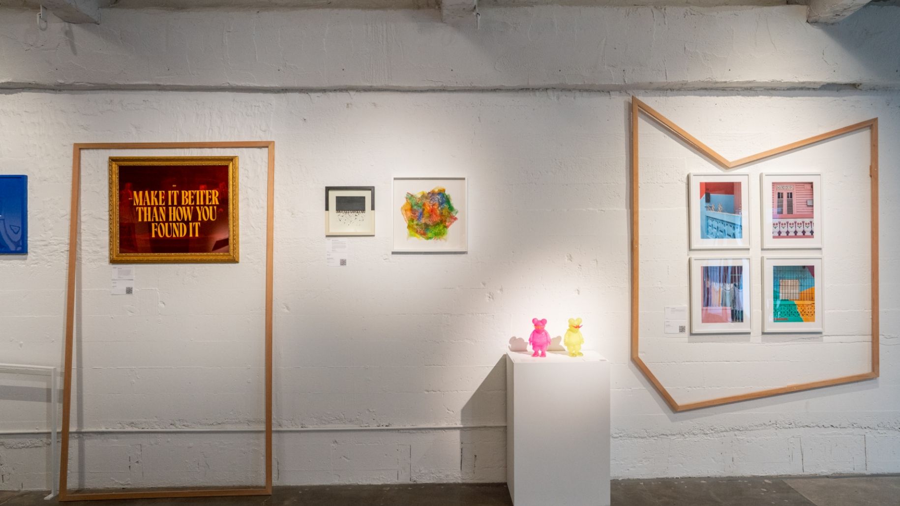 A group of framed artworks on display in an art gallery.