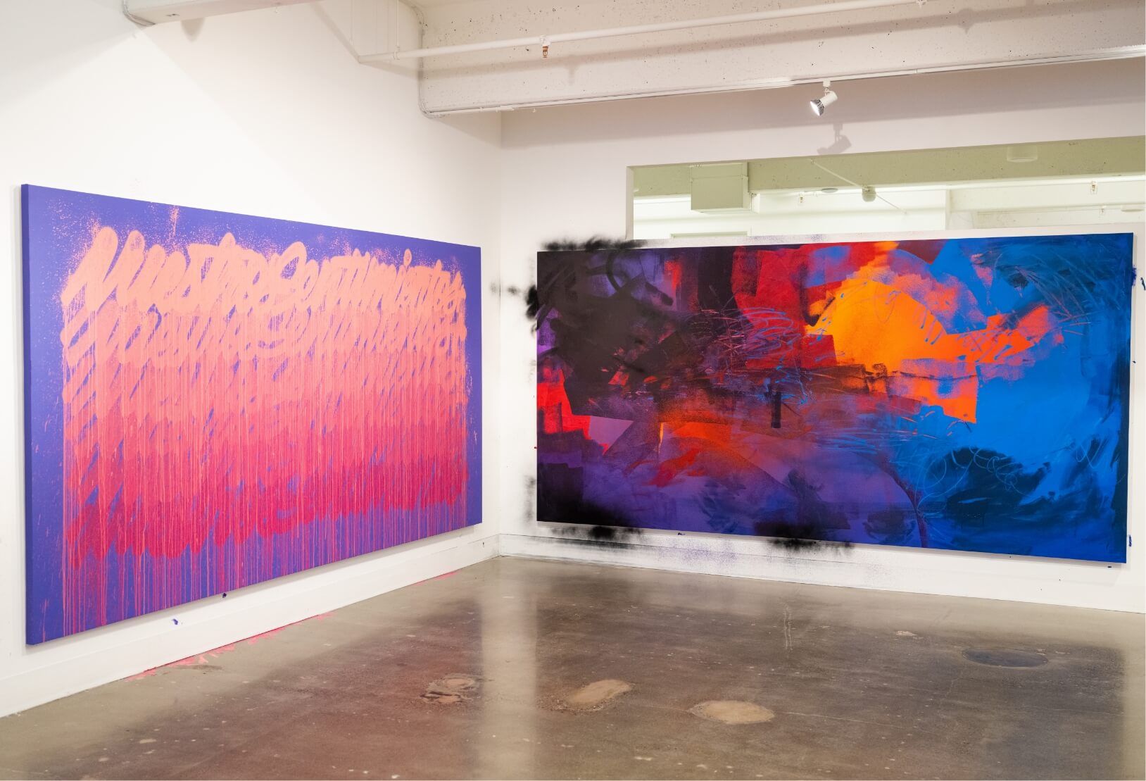 2 large colorful paintings on corner walls.