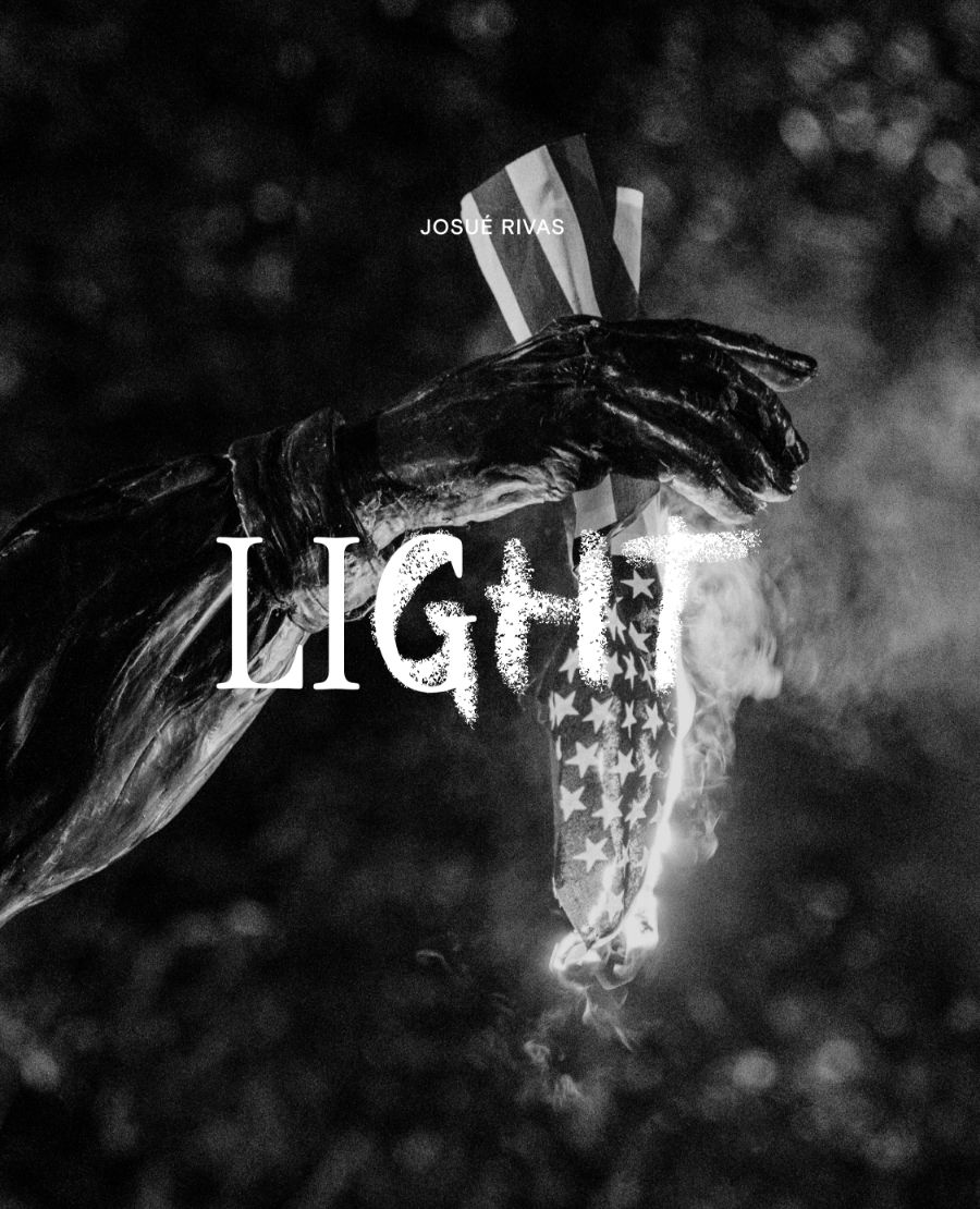 Light text over hand holding burning American flag